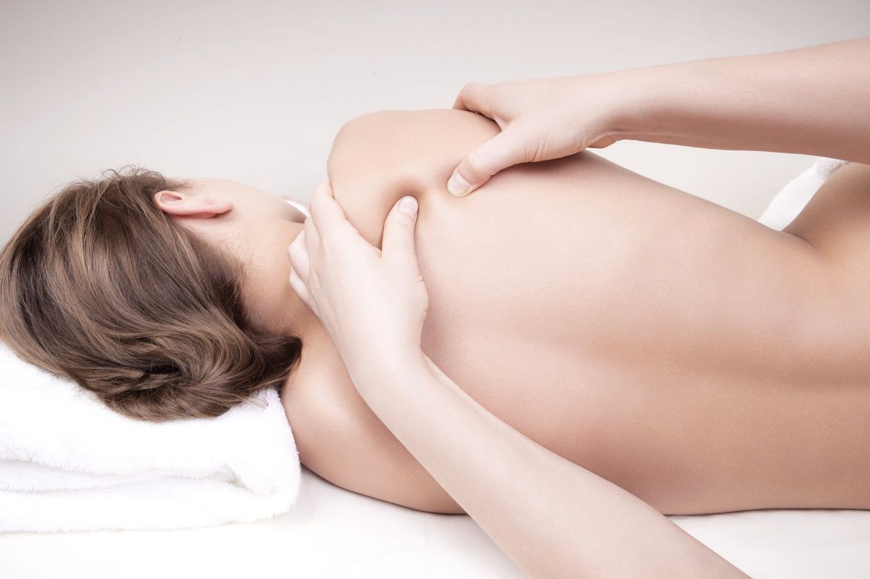 Fisioterapeurta-realizando-masaje-de-espalda-a-mujer